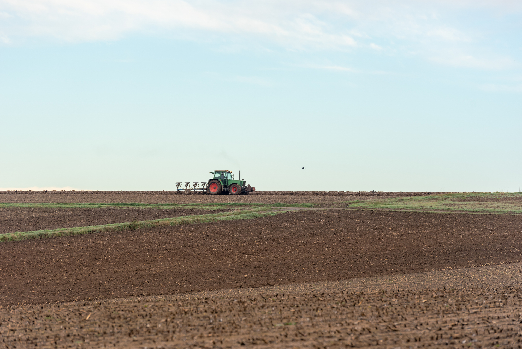 Tractor plowing agricultural fields outside of Stuttgart city, G